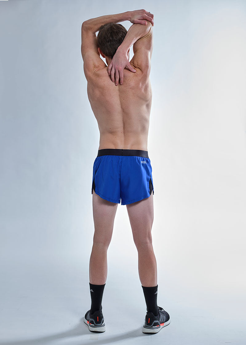 Full body rear stretching photo of the chicknlegs men's 2 inch royal blue split running shorts.