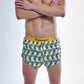 Front closeup view of the chicknlegs men's trippy pineapples 2 inch split running shorts.