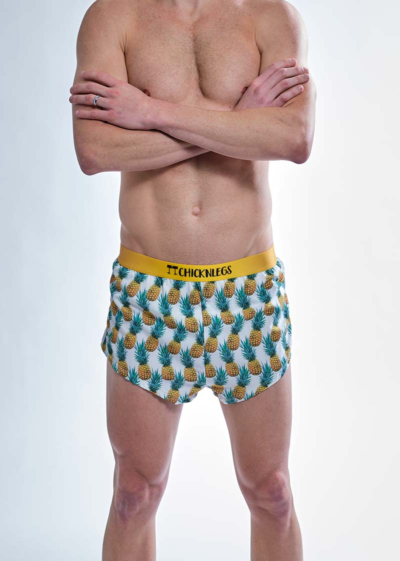 Front closeup view of the chicknlegs men's trippy pineapples 2 inch split running shorts.
