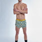 Full body view of the chicknlegs men's trippy pineapples 2 inch split running shorts.