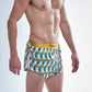 Side profile view of the split on the chicknlegs men's trippy pineapples 2 inch split running shorts.