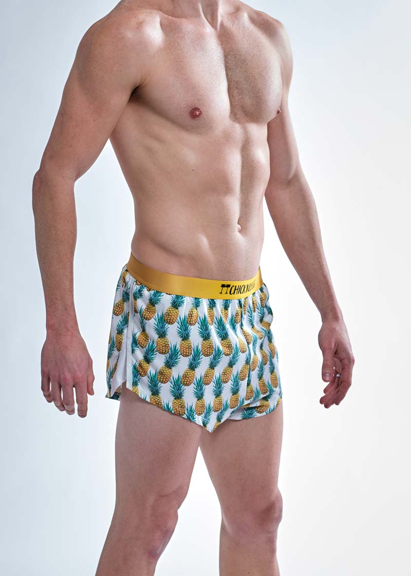Side profile view of the split on the chicknlegs men's trippy pineapples 2 inch split running shorts.