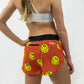 Rear view of the women's smiley face running shorts from ChicknLegs showing the zipper pocket and side split.