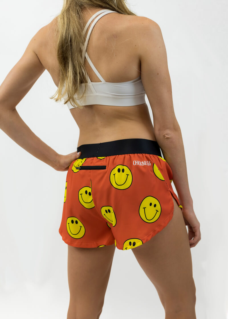 Rear view of the women's smiley face running shorts from ChicknLegs showing the zipper pocket and side split.
