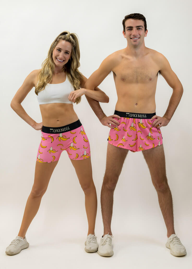 Runners posing in the men's and women's pink bananas running shorts from ChicknLegs.