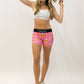 Runner playing with her har wearing the women's pink bananas compression running shorts from ChicknLegs.