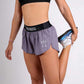 Closeup view of model stretching in the ChicknLegs women's 1.5" heather grey split running shorts.