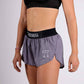 Logo side closeup view of the ChicknLegs women's 1.5" heather grey split running shorts.