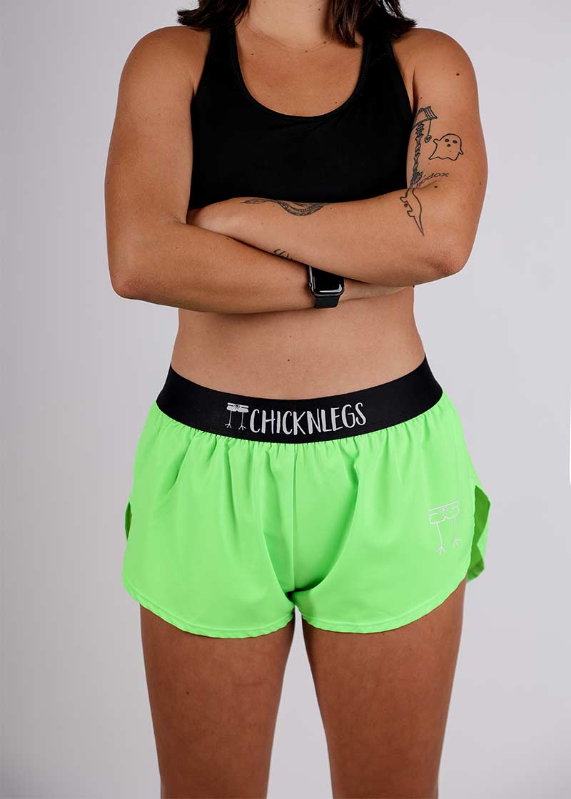 Front closeup view of the ChicknLegs women's neon green 1.5 inch split running shorts.