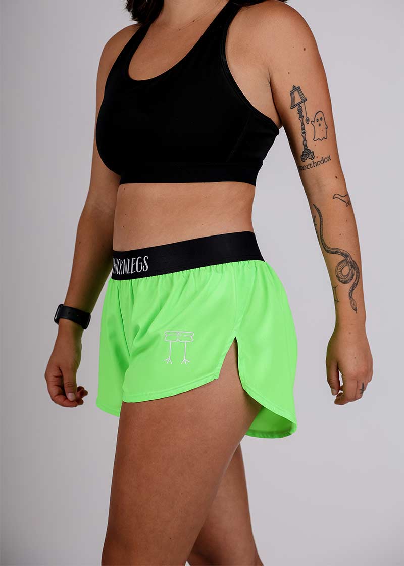 Side view of the ChicknLegs logo on the women's neon green 1.5 inch split running shorts.