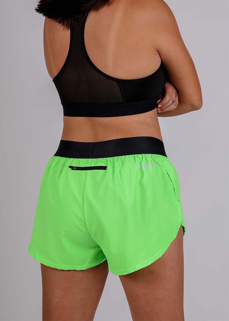 Rear view of the ChicknLegs women's neon green 1.5 inch split running shorts showcasing the back zipper pocket.