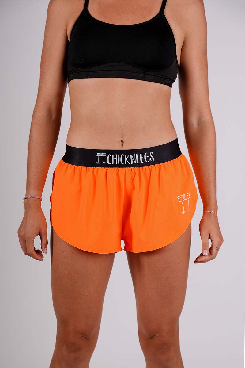 Front closeup shot of the women's 1.5 inch neon orange split running shorts.