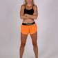Front full body shot of the women's 1.5 inch neon orange split running shorts.