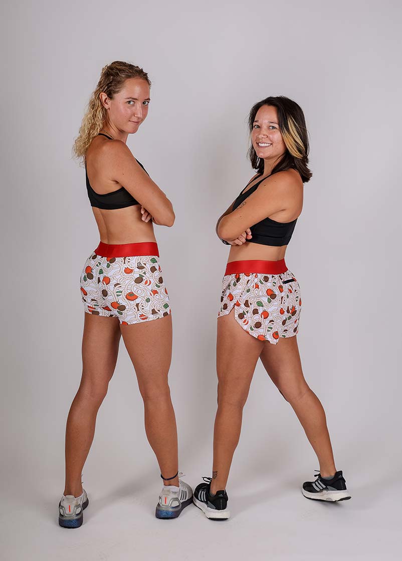 ChicknLegs women's 1.5" pasta night split running shorts full body  group shot while looking back.