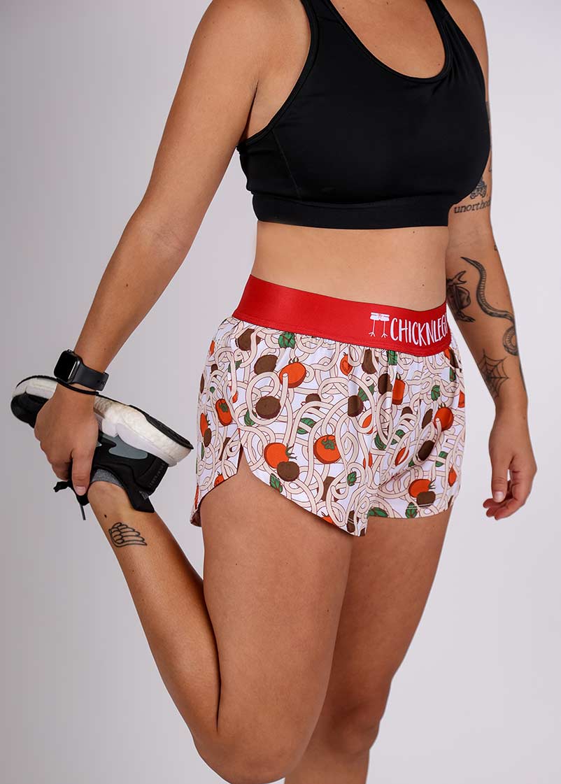 ChicknLegs women's 1.5" pasta night split running shorts front stretching view.