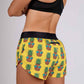 Rear closeup view from the left of the ChicknLegs pineapple express 1.5 inch split running shorts.