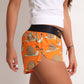 ChicknLegs women's snail's pace 1.5" split running shorts side view showcasing the side split with white tank top.