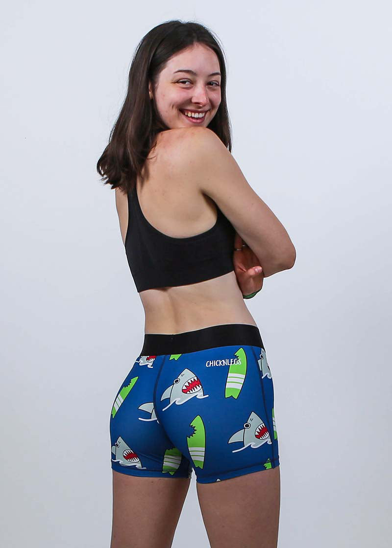 Back view of the women's 3 inch blue sharks compression shorts with model smiling.